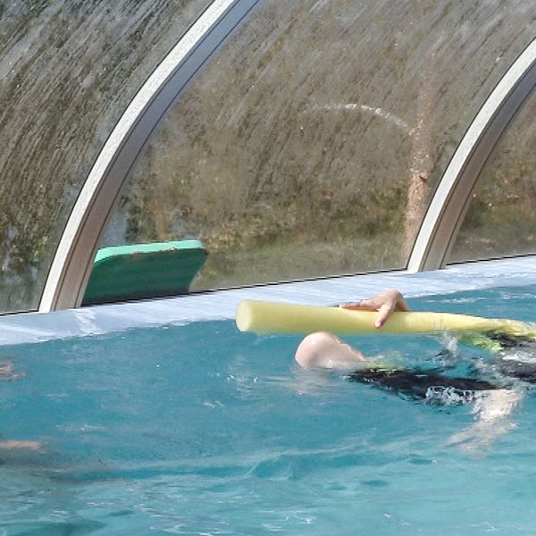 En bild på idrottsläraren Susanne Hansen tillsammans med ett barn i en pool.