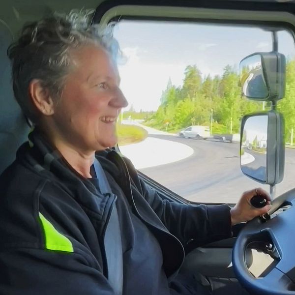 Lillemor från Burträsk, en kvinna i 60-årsåldern, sitter i lastbilen och ser glad ut när hon kör.