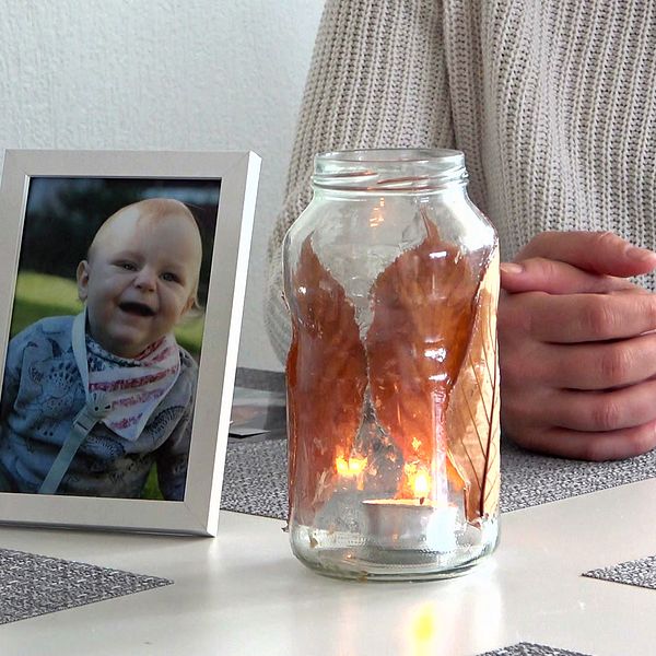 Matteos mamma sitter vid köksbordet vid en ljuslykta och en bild på sin son.