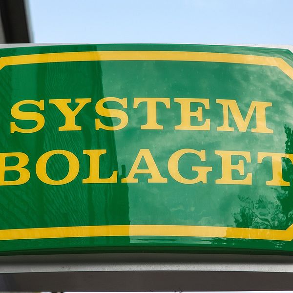 Bild på en grön skylt med gul text. Det står ”Systembolaget på skylten.