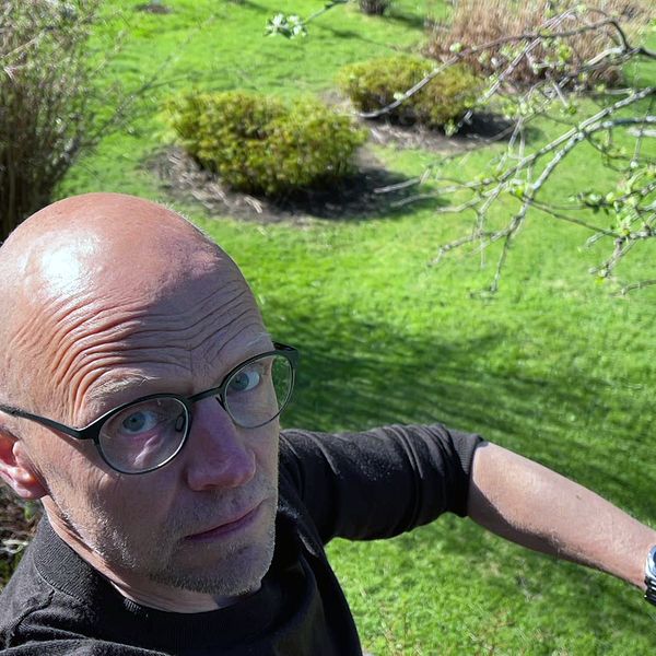 SVTs reporter Fredrik Israelsson står utomhus i sommarmiljö, han har en fästing på armen.