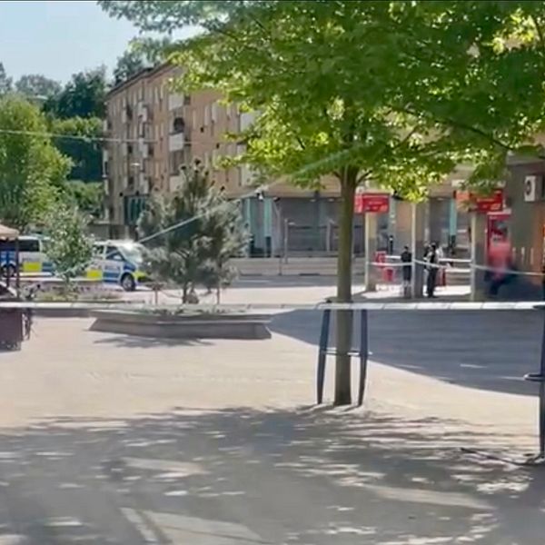 Bilden visar en polisavspärrning på ett torg.