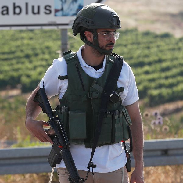 En beväpnad officer i militärkläder från Israels försvarsmakt står vakt vid den israeliska bosättningen på Västbanken.
