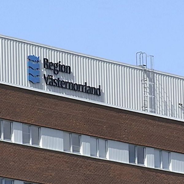 På bilden syns en byggnad som är byggd av tegelsten. Himlen är blå och på byggnaden finns en skylt där det står ”Region Västernorrland”.