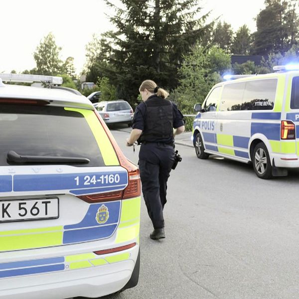 Polisbilar och polis på gatan där skjutningen skedde.