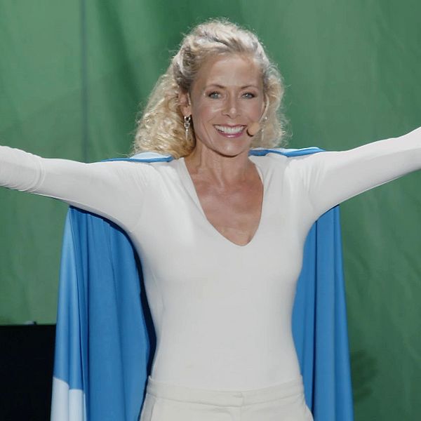 En leende Eva Röse, republiken Jämtlands president, står med med utsträckta armar på Storsjöyrans scen för att hålla det traditionsenliga presidenttalet vid midnatt.