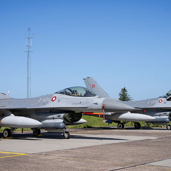 Två F-16-plan står på en militärbas.