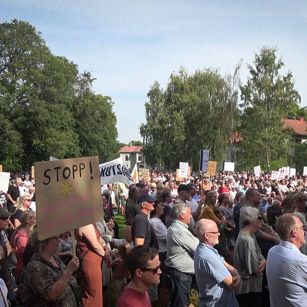 En folkmassa med plakat där de protesterar mot nedläggning av Lidköpings akutmottagning