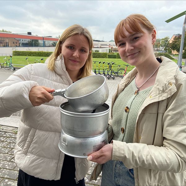 De blivande teaterpedagogerna Tilde Appelqvist och Hanna Hårstad Henriksson håller upp ett ihopsatt spritkök.