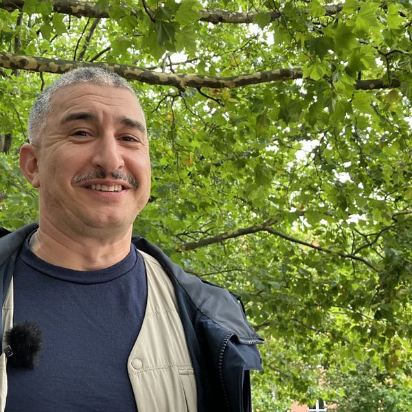 Patrick Bellan, trädspecialist på fastighets- och gatukontoret i Malmö, med träd bakom sig.