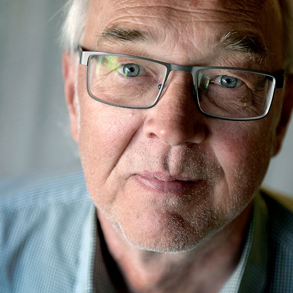 Yttrandefrihetsexperten Nils Funcke i smårutig skjorta mot ett draperi