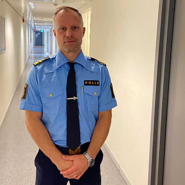 Emil Andersson, chef utredningsjour hos Polisen i Malmö står i en korridor. Bredvid en dörr där det står ”ARRESTEN”.