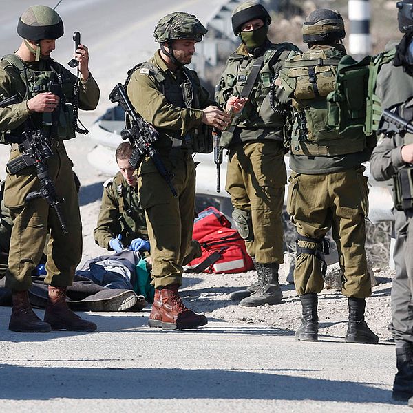 Israeliska soldater posterade runt kroppen av en palestinsk man som skjutits ihjäl efter att ha försökt hugga soldater på ockuperade Västbanken.