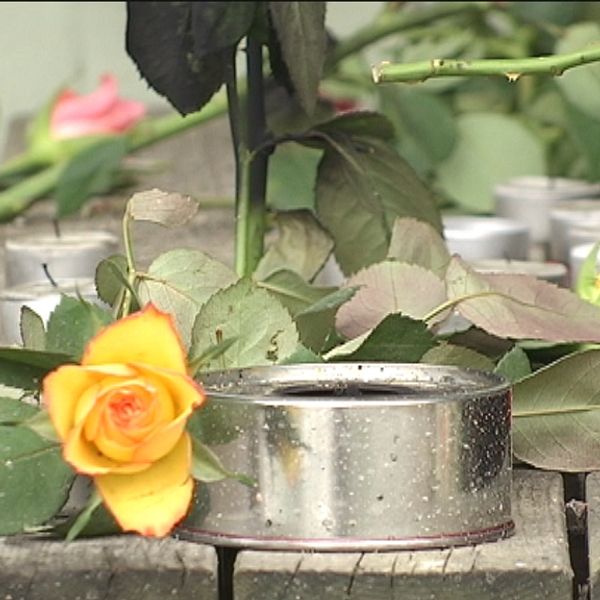 Blommor och ljus utanför lägenheten i Södertälje där två kroppar hittades i en studentlägenhet.