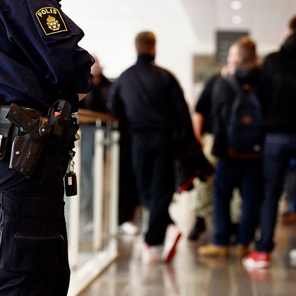 En polis står och och bevakar en rättegång i Södertörns tingsrätt.