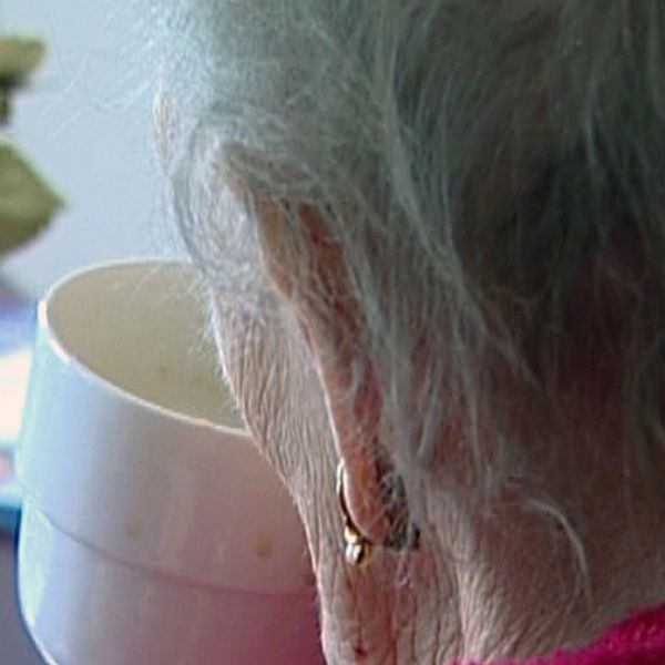 Äldre kvinna dricker kaffe