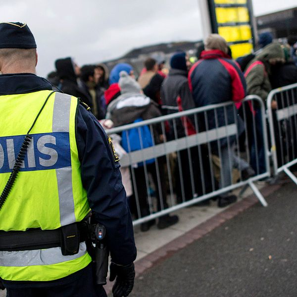 Polis bevakar flyktingar som anlänt till Sverige via tåg.