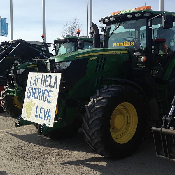 Traktor på Birstas parkering med skylt ”låt hela Sverige leva”.