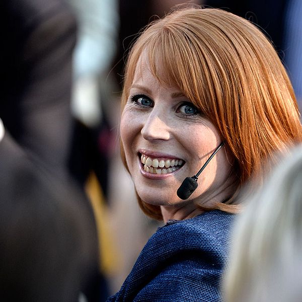 Annie Lööf som ler i en bland människor runtomkring.