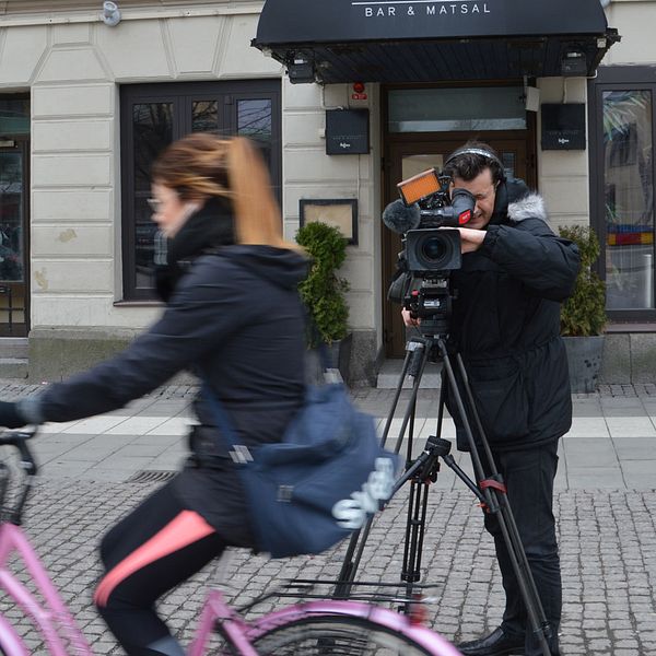 SVT:s fotograf framför restaurang