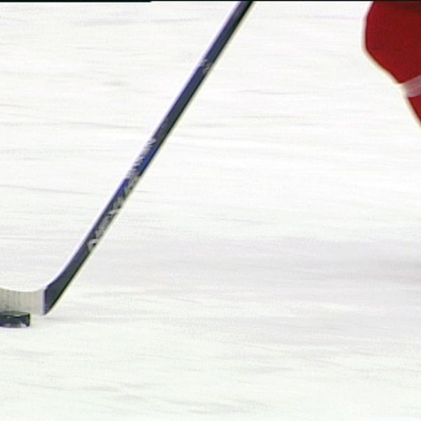 Hockeyspelare med klubba och puck på is.