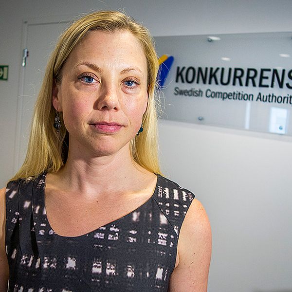 Blond kvinna tittar in i kameran. I bakgrunden syns skylt med texten ”Konkurrensverket”.