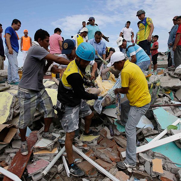 En skadad man dras fram från ett raserat hus i Ecuador