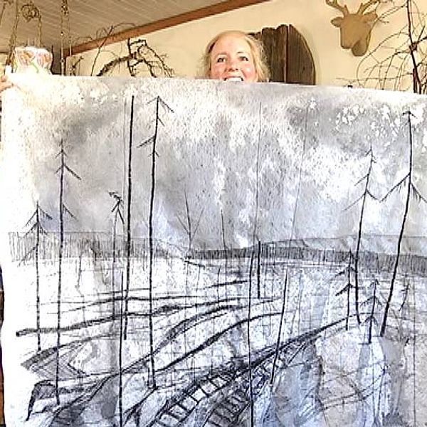 Linda Larsson visar ett stort broderi av ett kalhygge.