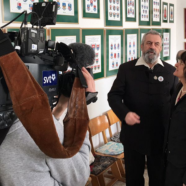 Byns skola pryds av Daniel Pecsis många verk i samband med välsignelsen av Maconkas nya flagga.