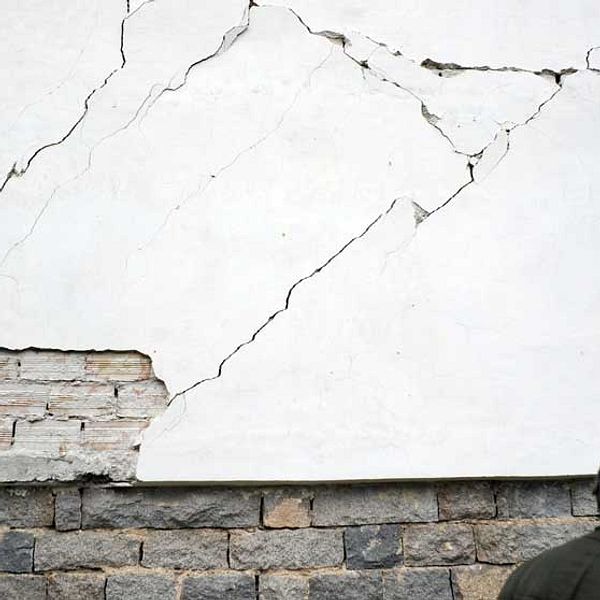 En man framför sitt förstörda hus i byn Rudarci utanför Pernik. AFP PHOTO / NIKOLAY DOYCHINOV