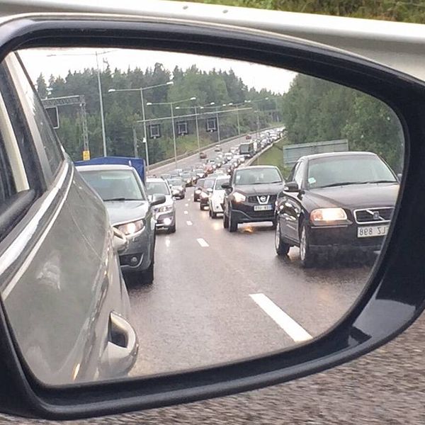 Bilköer sedda via sidospegel på bil.