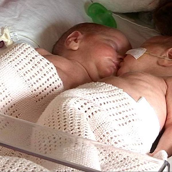 Två nyfödda barn i en sjukhussäng.
