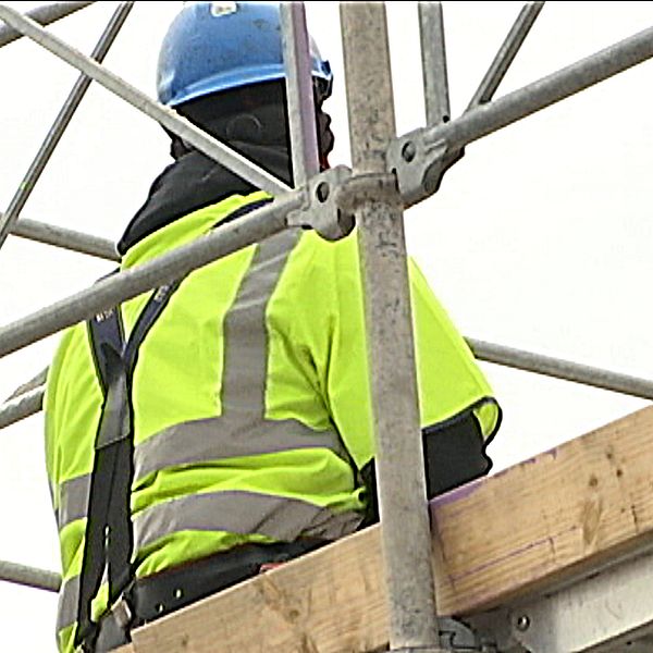 En byggnadsarbetare står på en byggarbetsplats.