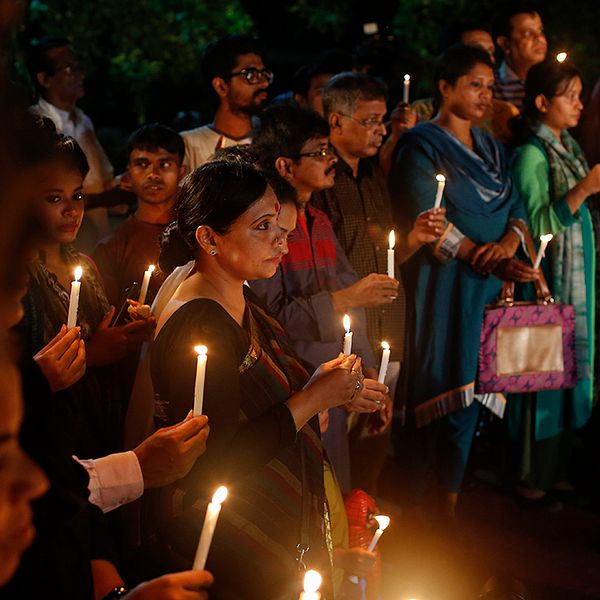 Invånare i Dhaka tänder ljus till minne för offren i massakern på en restaurang i helgen.