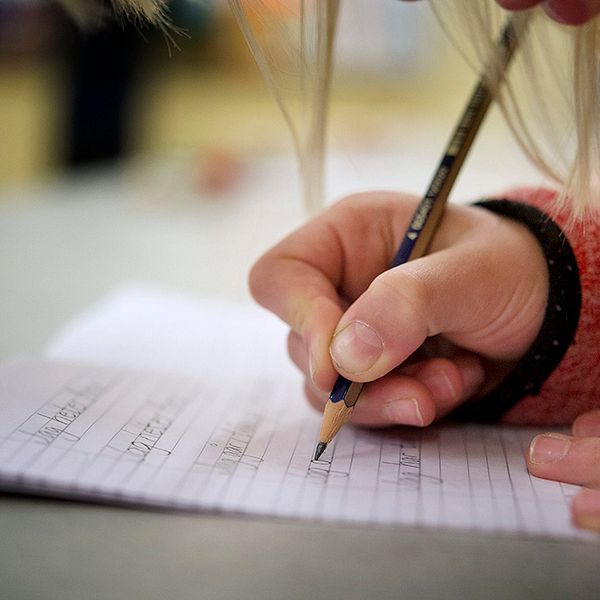 Hand som skriver i skolan, lågstadieelev