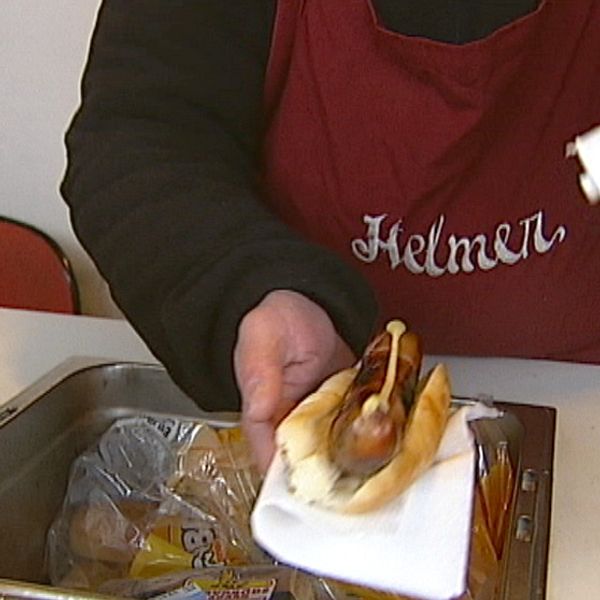 Helmer Holm fixar en varmkorv i sin varma korvkiosk.