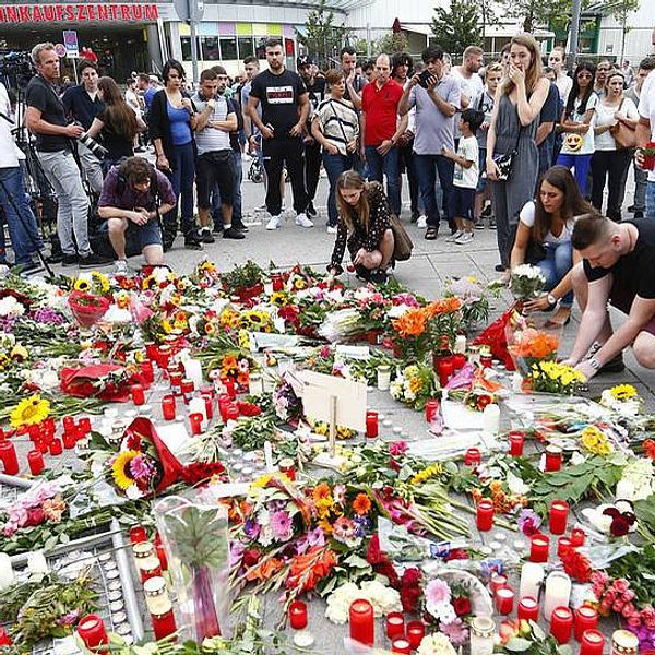 Människor lägger blommor framför shoppingcentrumet där fredagens skottdrama ägde rum.