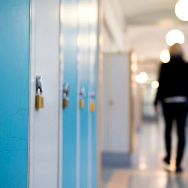 En elev går i skolkorridor.