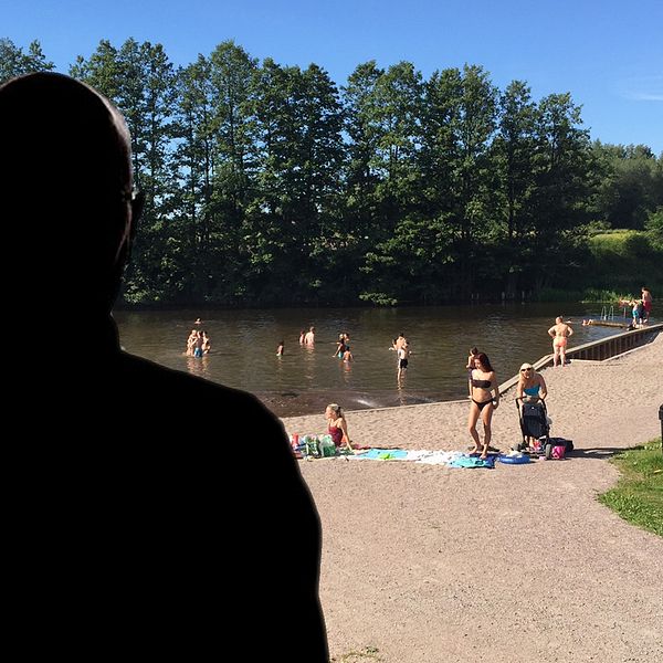 Silhouette på en man med bild på en badplats i bakgrunden.