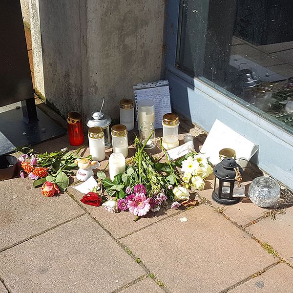 Blommor, ljus och skriftliga hälsningar på platsen där den hemlöse mannen mördades.