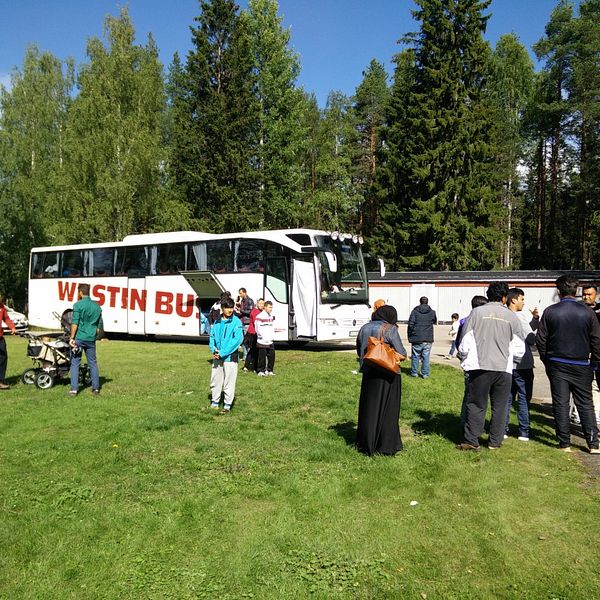 asylsökande i krokströmmen står utanför en buss