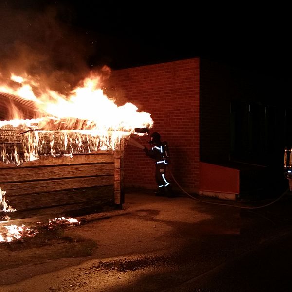 Brandman släcker brand i container