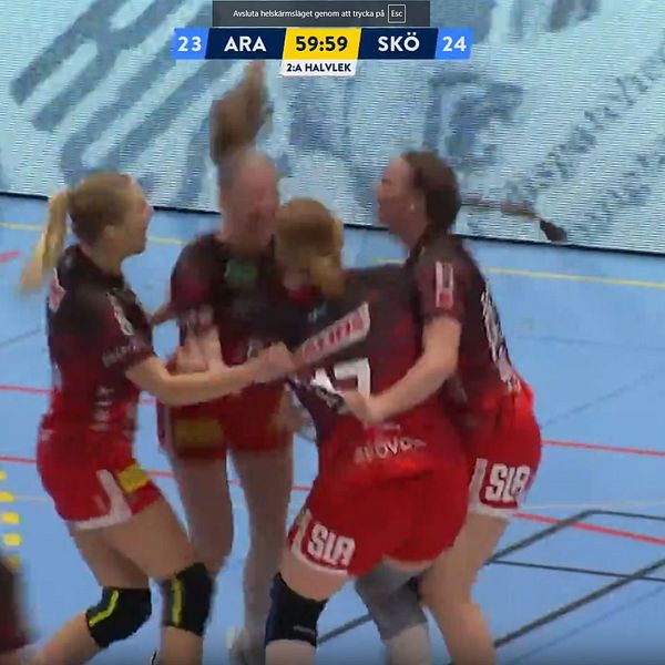 Fyra handbollsspelare i röd-svarta matchdräkter firar tillsammans på planen under en match. Spelare från laget Skövde vinner över Aranäs med ställningen 24-23, medan matchens klocka visar 59:59.