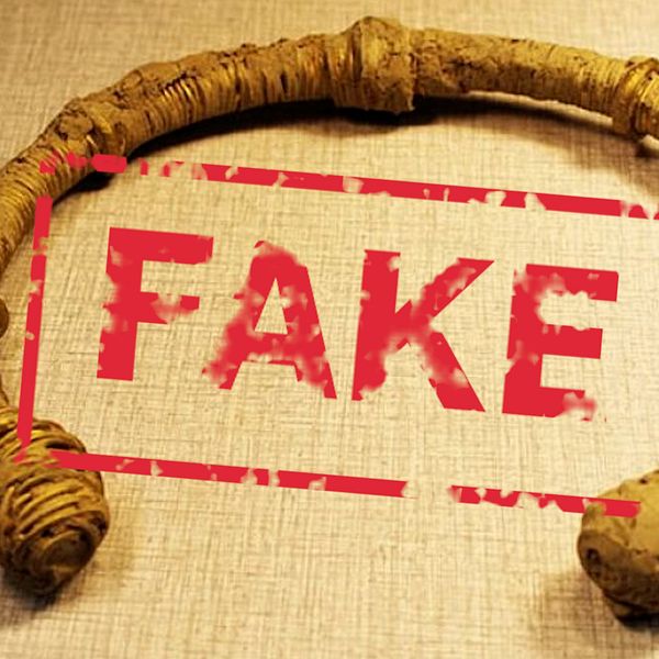 Antik ring med ordet ”FAKE” tryckt i rött över.