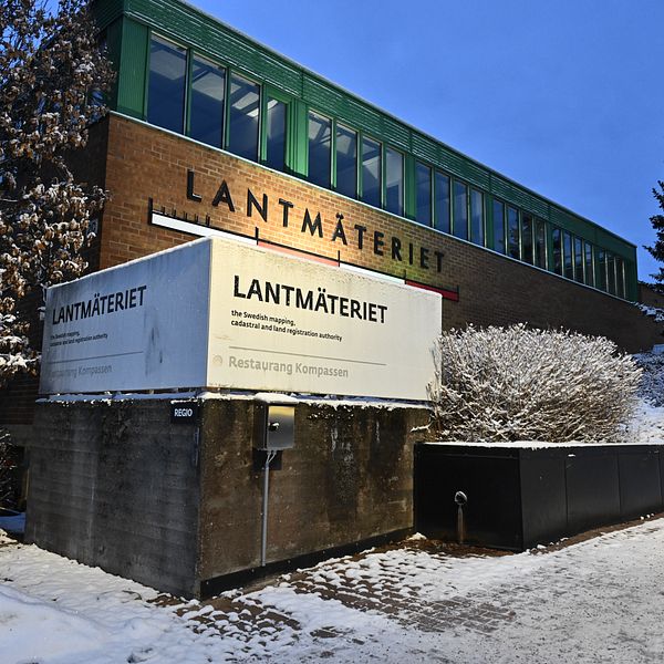 Lantmäteriets byggnad i vintrig miljö, med mörkblå himmel och snö på marken.