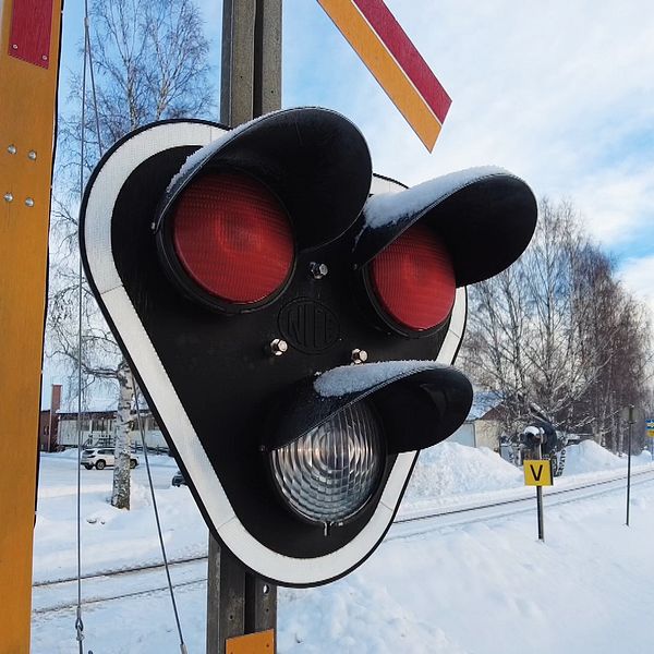 En stoppsignal vid en järnvägsövergång i vinterlandskap
