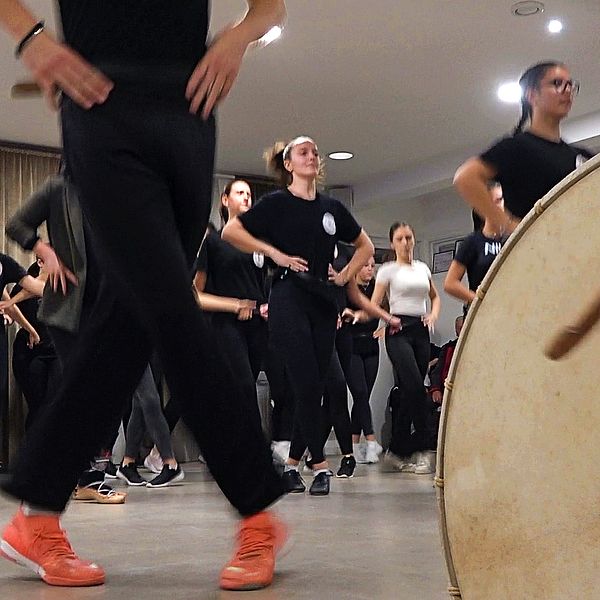 Fötter och människor på dansgolv med trumma i förgrunden
