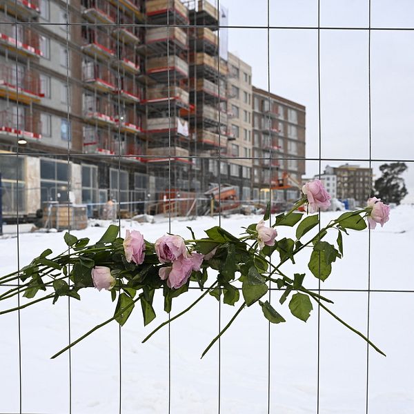 Blommor vid stängslet till arbetsplatsen i Sundbyberg där en bygghiss rasade