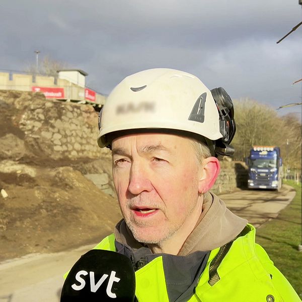 En arkeolog i arbetskläder och hjälm intervjuas av SVT vid bastionen i Halmstad där de hittat ett dolt kanonrum. Bakom personen syns en lastbil och en jordhög, samt en delvis molnig himmel.