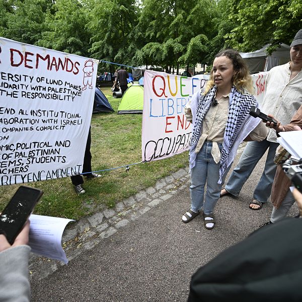 Demonstranter i Lundagård med plakat.